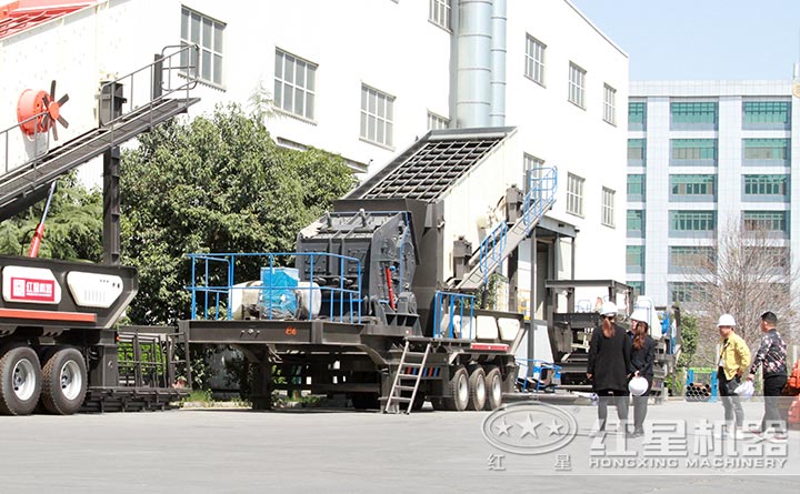 客戶參觀移動反擊式粉碎、篩分機，技術(shù)人員陪同并講解機器運行情況